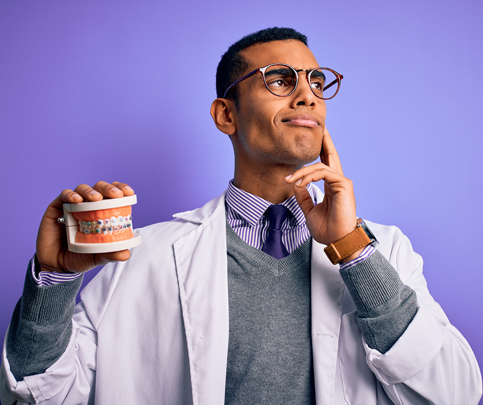 Orthodontist holding dentures with braces